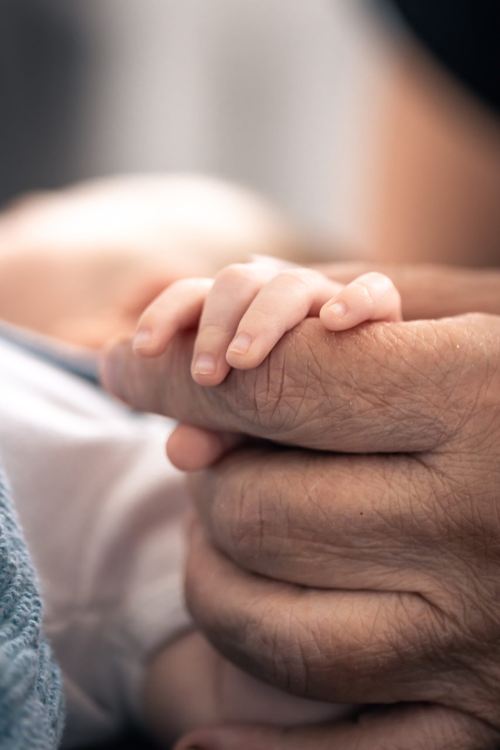 alt="Hands of senior person and little baby close up — Forever Told NSW memoir writing service"